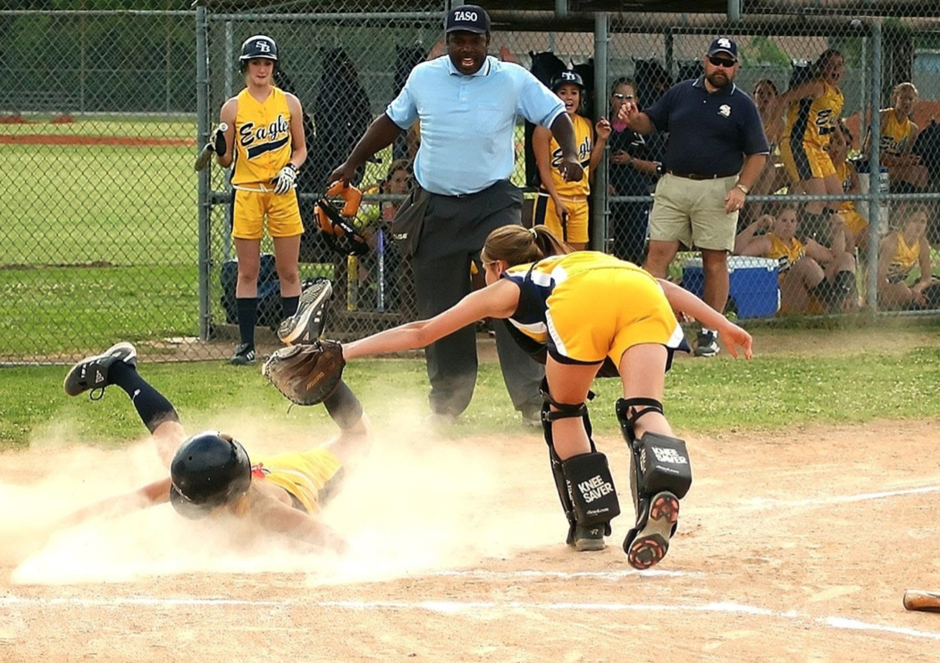 Softball player sliding into home base
